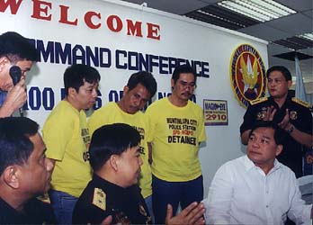 リナ内務自治長官(前列右)が見守る中、引き出された容疑者3人を逮捕した首都圏警察モンテンルパ署の功績を拍手で称えるベラスコ首都圏警察総監(後列右)ら