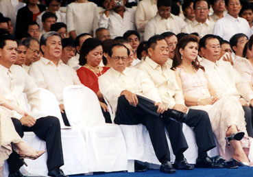 大統領就任演説をじっと見守るラモス元大統領(中央)とデベネシア下院議長(右隣)‖6月30日、リサール公園で写す