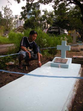 父親の墓にペンキを塗り終えたファフタガナさん=首都圏マカティ市のマニラ南墓地で30日午後3時ごろ写す