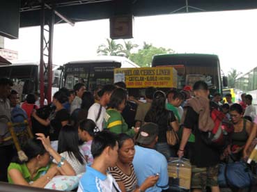 帰省者で混雑するケソン市クバオのバスターミナル=31日午後1時ごろ写す