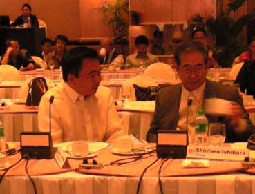 ANMC21の本会議で談笑するフェルナンド局長と石原都知事(右)=首都圏パサイ市内のホテルで27日正午すぎ写す