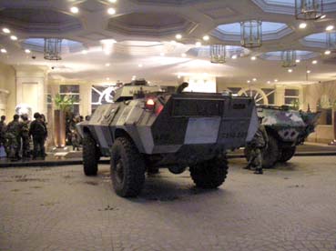 ホテル内に強行突入した軍・警察部隊を見守る国軍装甲車=首都圏マカティ市のペニンシュラホテル正面玄関前で29日午後6時10分ごろ写す