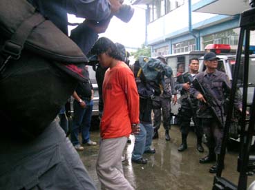 警官隊が警戒する中、入廷する被告の元アブサヤフ構成員=6日午前8時20分ごろ写す