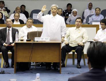 上院聴聞会の証言前、右手を上げて宣誓するボランテ元農務次官(中央)=上院事務局提供