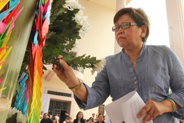 震災犠牲者を追悼し、白菊を供える集会出席者=11日午後1時50分ごろ、首都圏ケソン市のフィリピン大で写す