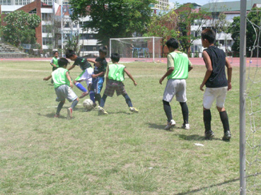 炎天下のグラウンドを元気に駆け回る子供たち=13日午前10時45分ごろ、首都圏パシッグ市のフィルスポーツ・コンプレックスで写す