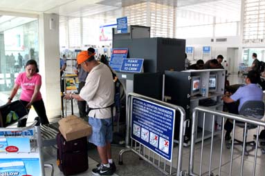 手荷物を乗せる乗客ら=マニラ空港第2ターミナル入り口のX線検査所で写す