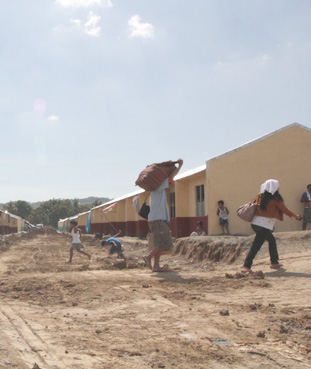 山々に囲まれた再定住地に建設された住宅