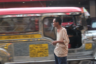 幹線道路沿いで喫煙する男性=首都圏マカティ市で写す