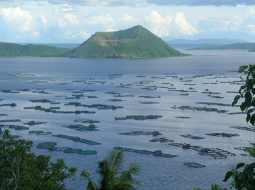 湖面に広がるミルクフィッシュの養殖場。奥はタール火山=5日午後1時ごろ、ルソン地方バタンガス州タリサイ町サンパロックで写す