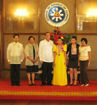 模範的な比人海外就労者に贈られる「新しい英雄賞」を受賞したオタカンさん(右から3人目)らとアキノ大統領(同4人目)=1日午前10時半すぎ、首都圏マニラ市のマラカニアン宮殿で写す