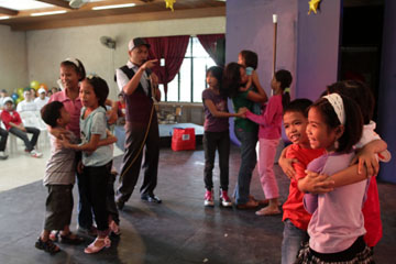 壇上でゲームをする子どもら=10日午前10時20分ごろ、首都圏モンテンルパ市で写す