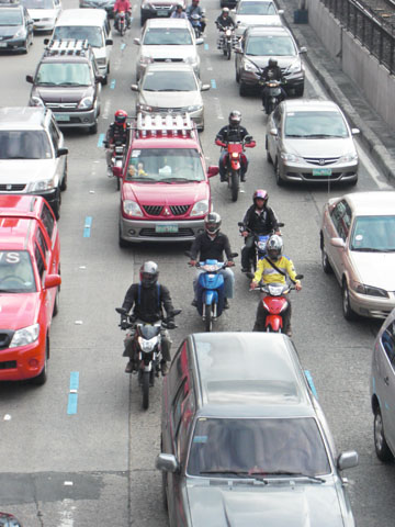 エドサ通りに新設された車線を走るオートバイ=首都圏マカティ市で写す