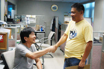 首都圏警察マニラ市本部の捜査に協力したマカティ署の署員と岩崎さん(左)=13日午後1時ごろ首都圏マカティ署で写す