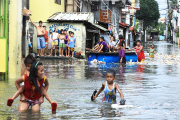 急造のいかだに乗る住民ら=2日午後2時ごろ、首都圏ナボタス市で写す