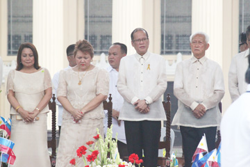 国旗掲揚・献花式典に出席したアキノ大統領(右から2人目)=13日午前8時36分、首都圏マニラ市のボニファシオ像前で写す
