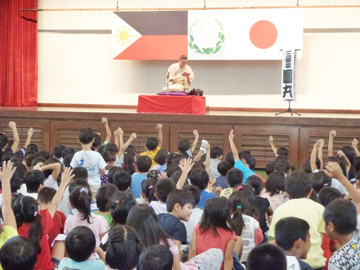 圓丸さんの身ぶりや表情を見て、何をしているのか当てるゲームを楽しむ子供たち=26日午後1時50分ごろ、首都圏タギッグ市のMJSで写す