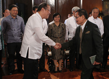 マラカニアン宮殿で移行委員会のイクバル委員長(右)と握手するアキノ大統領=大統領府提供