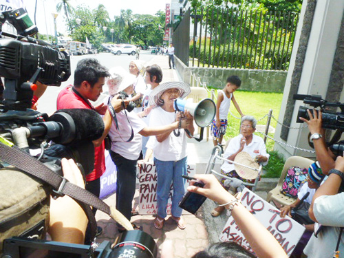 抗議集会で「戦争に逆戻りする」と訴える参加者=25日午前11時15分ごろ、首都圏パサイ市の日本大使館前で写す