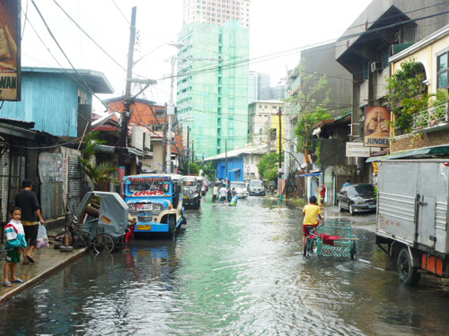 雨の影響で冠水した台風直後の首都圏マカティ市の住宅密集地ピオデルピラール=16日午前11時ごろ写す
