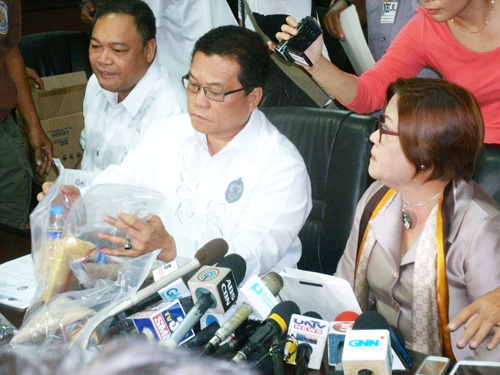 記者会見で、押収した爆発物を見せるメンデス局長(中央)とデリマ長官(右端)=2日午前10時20分ごろ、NBIで写す