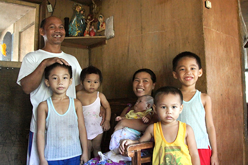 妻と子供5人に囲まれたリッキー・アギホンさん(左端)=8日午前、タクロバン市で写す