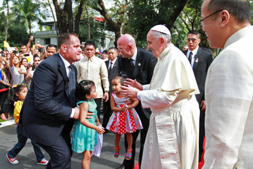 マラカニアン宮殿の歓迎式典で、子供たちを祝福するローマ法王。右手前はアキノ大統領=大統領府提供