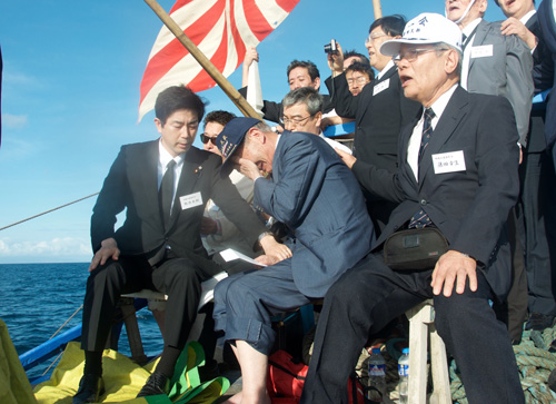 洋上慰霊祭で感極まり、顔を両手で覆う早川さん=26日午前7時すぎ写す
