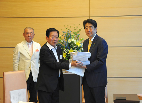 安倍晋三首相に要望書と署名簿を手渡す日系人会連合会代表団のカルロス寺岡・前会長(中央)=日本財団提供