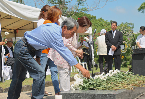 兄がレイテ州で戦死し、白菊を献花する丸山昇さん(左手前)=15日 午前9時50分ごろ、ルソン地方ラグナ州のカリラヤ慰霊園で写す