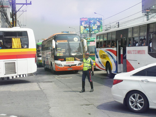 渋滞したエドサ通りで取り締まりをする警官=7日午前9時半ごろ、首都圏ケソン市で写す