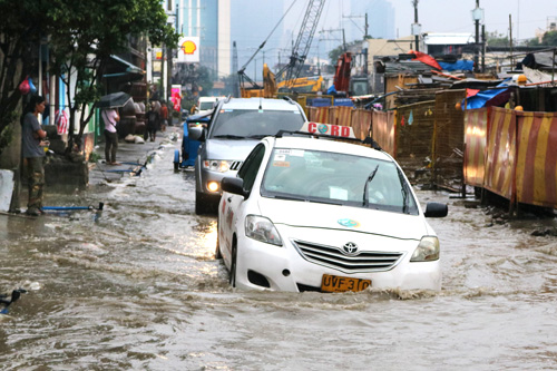 豪雨によって冠水した道路=15日午後4時45分、首都圏マンダルーヨン市で写す