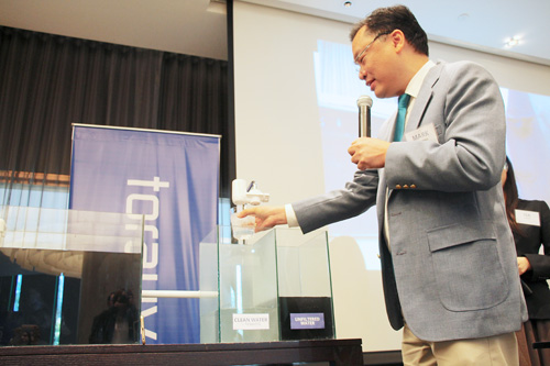 インクで水に色を付けて、トレビーノの性能を見せるデモンストレーション=30日午後1時ごろ、首都圏マカティ市内のホテルで冨田すみれ子写す