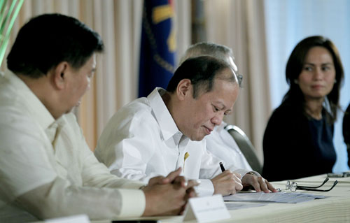 被災した子どもの権利を守る法案に署名するアキノ大統領=大統領府提供