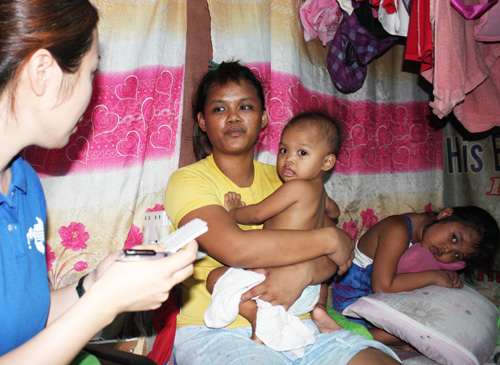 NGO職員の質問に答えるパヤタスの住民=首都圏ケソン市パヤタスで立田成美写す