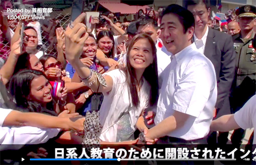 動画では、ミンダナオ国際大学で写真撮影に応じる安倍首相の様子が映されている=首相官邸のフェイスブック・アカウントより