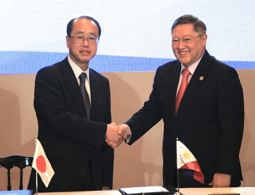 協議後に握手を交わす和泉洋人首相補佐官とドミンゲス財務長官=7日午後0時半ごろ、首都圏マニラ市で森永亨撮影