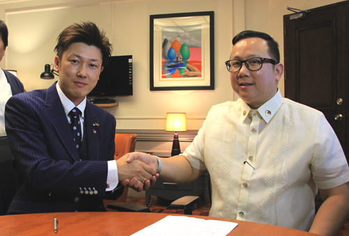 寄付申出書に署名後、握手を交わす沼崎孝則さんとガットパヤット次官=11日午後2時20分ごろ、首都圏マニラ市で森永亨撮影