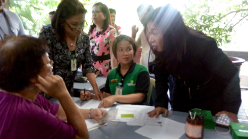 補償金のキャッシュカードを受け取る人権被害者=5月8日午後1時半ごろ、首都圏ケソン市のフィリピン大でアラーナ・アンビ撮影