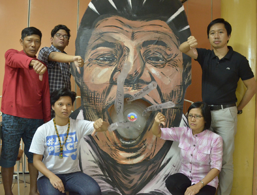 大統領の似顔絵パネルを囲み、人権侵害を非難する参加者ら=14日午前9時ごろ、首都圏ケソン市で伊藤明日香撮影