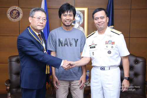 救出されたベトナム人船員(中央)の引き渡しに臨むリ駐比ベトナム大使(左)とメルカド海軍中将(右)=海軍提供