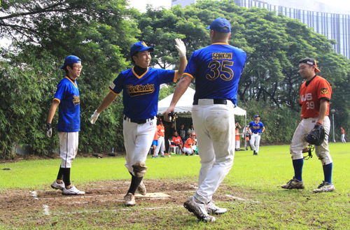 4回、2ランを放ち山根とハイタッチするトゥーホィーラーズ宮永(左から2人目)=15日午前8時ごろ、首都圏タギッグ市で森永亨撮影