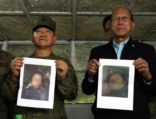死亡が確認されたハピロン、オマル両容疑者の写真を掲げるアニョ国軍参謀総長(左)とロレンサナ国防長官(右)=16日午後、ミンダナオ地方南ラナオ州マラウィ市の国軍前線本部で撮影(一部を加工しています)