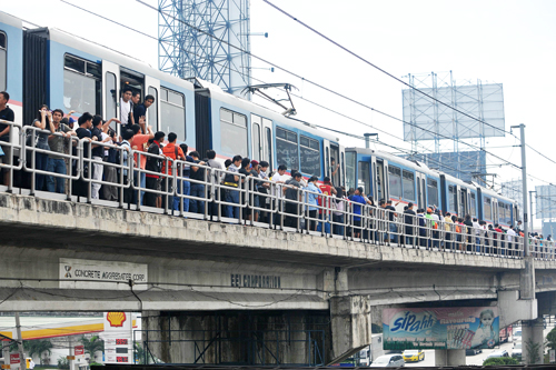 首都圏鉄道(MRT)3号線のブレーキ故障により線路上を歩いて移動する乗客=2011年1月撮影(AFP=時事)