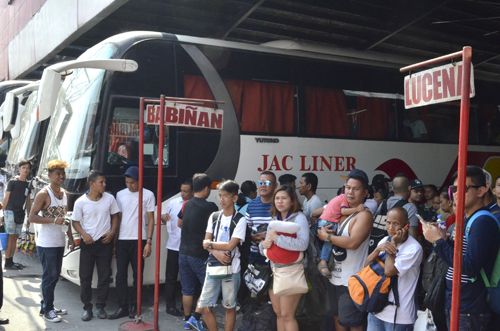 炎天下のバスターミナルで行き先ごとに長い列をつくる帰省客=28日午後2時ごろ、首都圏パサイ市で伊藤明日香撮影