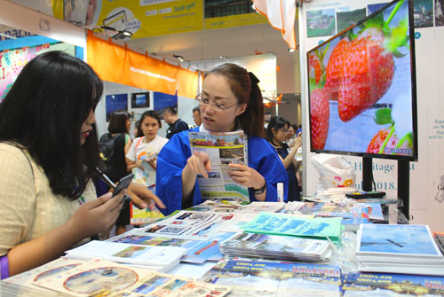 県内各観光名所などのパンフレットを見せながら来場者に説明する長崎県観光関係者=6日午後3時半ごろ、首都圏パサイ市で冨田すみれ子撮影