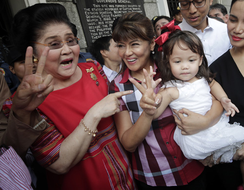 候補者登録を行うアイミー・マルコス北イロコス州知事(中央)とイメルダ・マルコス下院議員(左)=16日、首都圏マニラ市で撮影(EPA=時事)