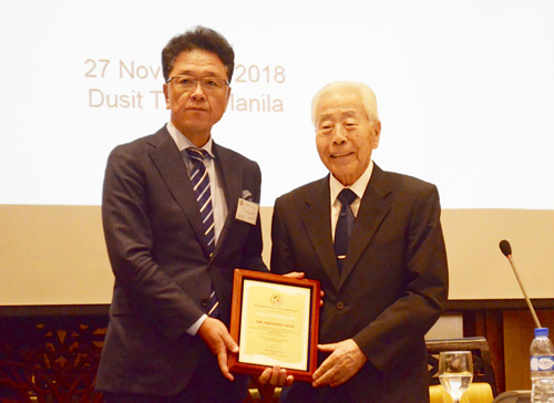 マニラ日本人会の清水光彦会長から記念品を受け取る家田昌彦監事=27日午後、首都圏マカティ市で伊藤明日香撮影