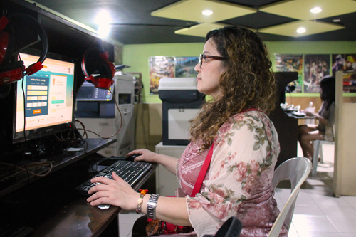 パソコン利用店でネットを利用し航空チケットを予約する女性=5日午後8時ごろ、首都圏マカティ市で冨田すみれ子撮影