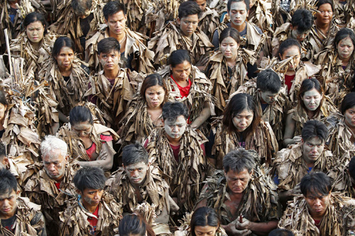 全身に泥を塗りバナナの葉をまとった「泥の人祭り」参加者(EPA=時事)